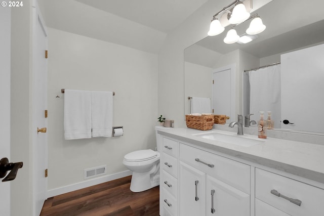 bathroom featuring hardwood / wood-style floors, vanity, toilet, and a notable chandelier