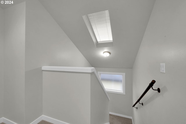 stairs featuring carpet floors and vaulted ceiling