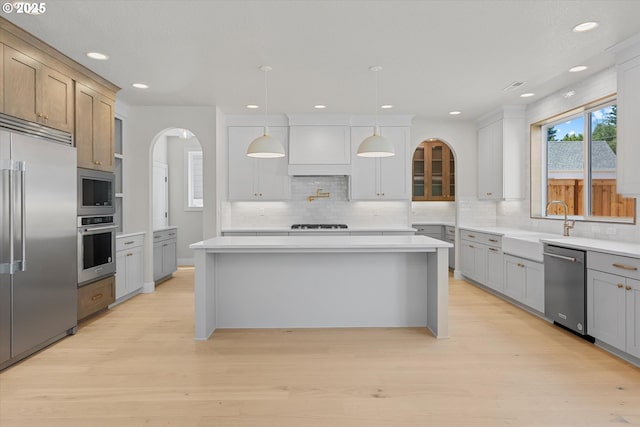 1218 9th St Lot 3, West Linn, OR 97068 - kitchen with built in appliances, arched walkways, decorative backsplash, light wood-style flooring, and recessed lighting