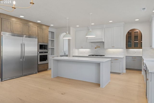 1218 9th St Lot 3, West Linn, OR 97068 - kitchen with built in appliances, arched walkways, light wood-style flooring, light countertops, and recessed lighting