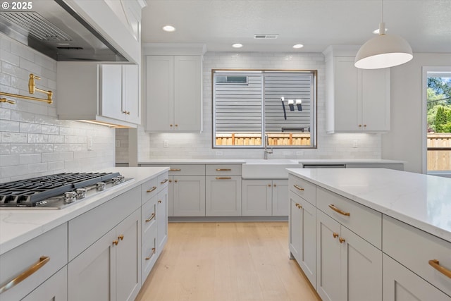 1218 9th St Lot 3, West Linn, OR 97068 - kitchen featuring a sink, wall chimney exhaust hood, stainless steel gas stovetop, tasteful backsplash, and light wood-style flooring