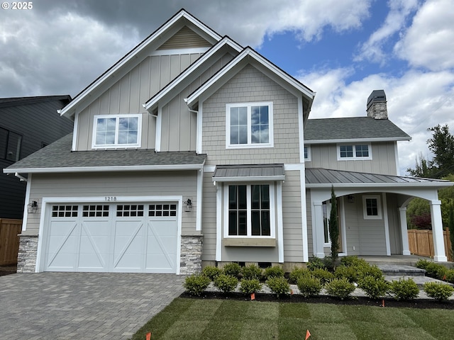 view of front of home featuring board and batten siding, a chimney, and a garage