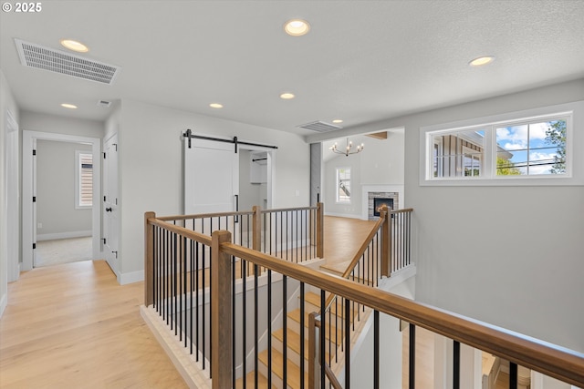 1218 9th St Lot 3, West Linn, OR 97068 - hall featuring an upstairs landing, recessed lighting, light wood-style floors, baseboards, and a barn door