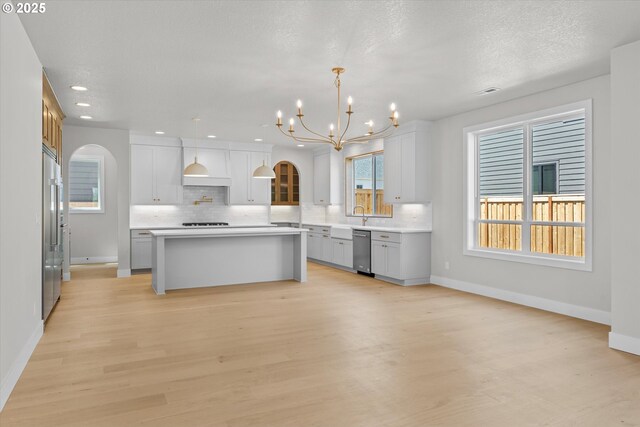 1218 9th St Lot 3, West Linn, OR 97068 - kitchen with stainless steel appliances, arched walkways, tasteful backsplash, light wood-style flooring, and recessed lighting