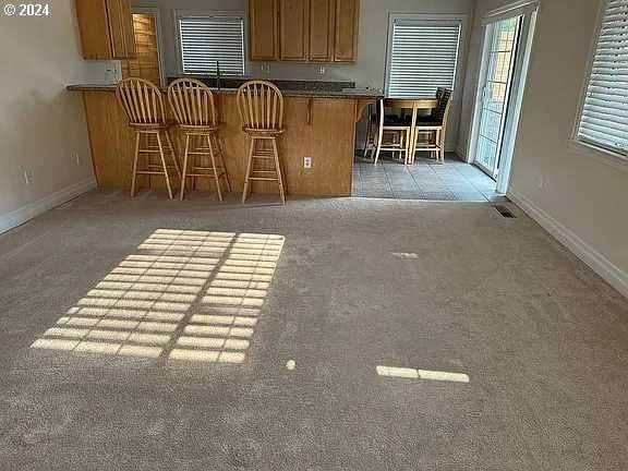 kitchen featuring dark carpet, sink, a breakfast bar, and kitchen peninsula