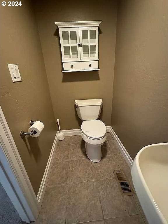 bathroom with toilet and tile patterned flooring