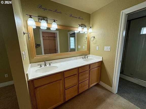 bathroom with tile patterned floors, vanity, and a shower with door