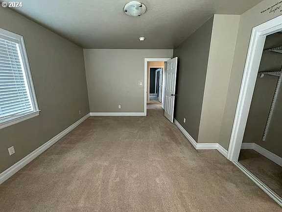 unfurnished bedroom featuring light carpet and a closet