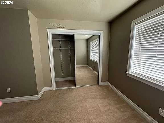 unfurnished bedroom featuring carpet and a closet