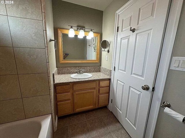 bathroom with vanity, tile patterned flooring, and a tub