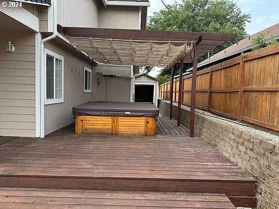 wooden terrace with a pergola and a covered hot tub