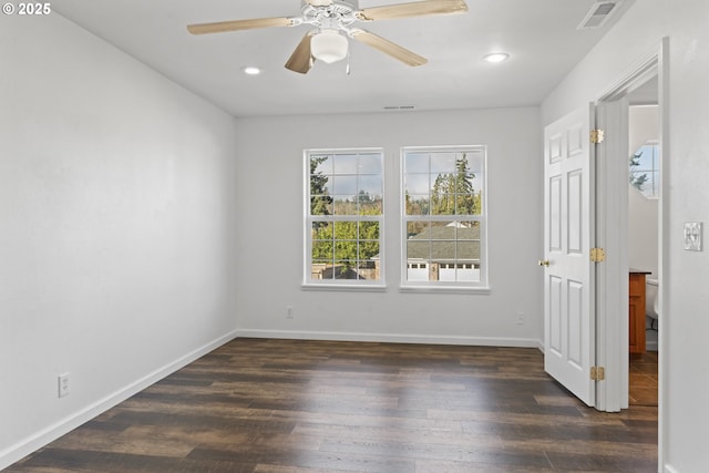 empty room featuring dark wood-style floors, recessed lighting, visible vents, and baseboards