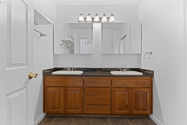 full bath with double vanity, a sink, and tile patterned floors