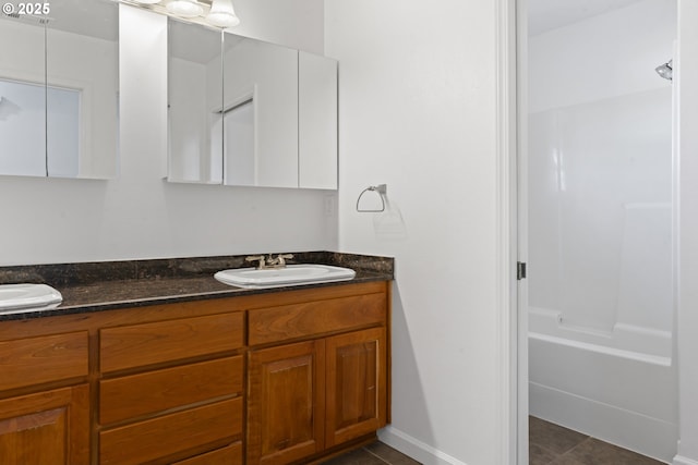 bathroom featuring double vanity, a sink, and tile patterned floors