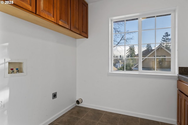 laundry room with hookup for a washing machine, hookup for an electric dryer, dark tile patterned flooring, baseboards, and cabinet space