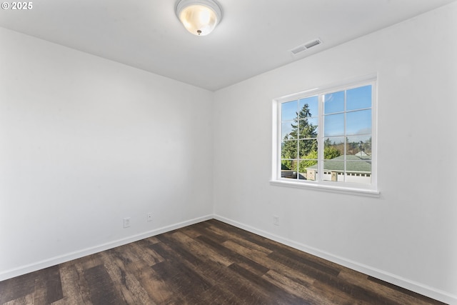 unfurnished room with dark wood-style floors, baseboards, and visible vents