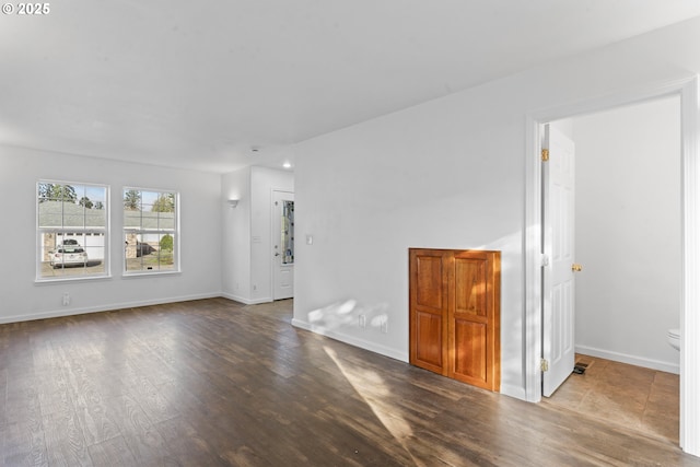 spare room featuring visible vents, baseboards, and wood finished floors