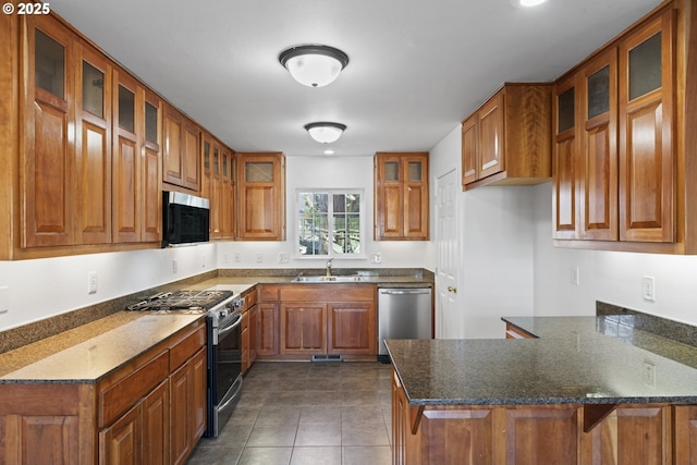 kitchen with stainless steel appliances, a peninsula, and brown cabinets