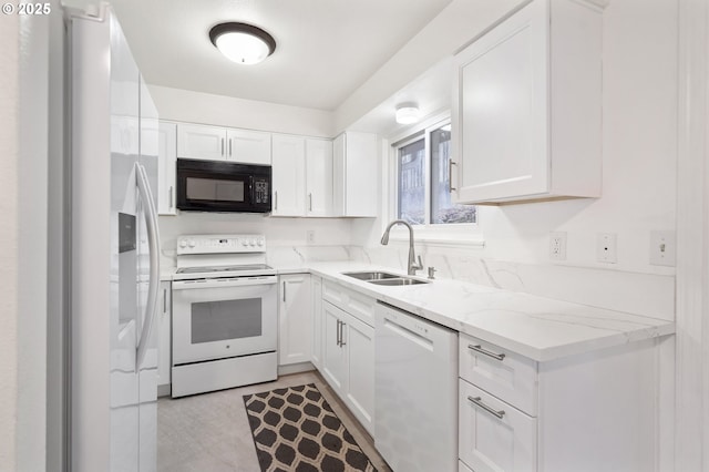 kitchen featuring white appliances, white cabinetry, and sink