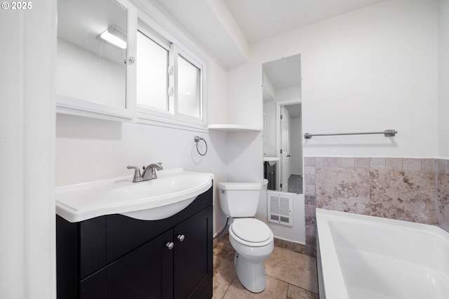 bathroom with tile patterned floors, a washtub, vanity, and toilet