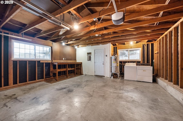 garage with secured water heater, washer and dryer, and a garage door opener