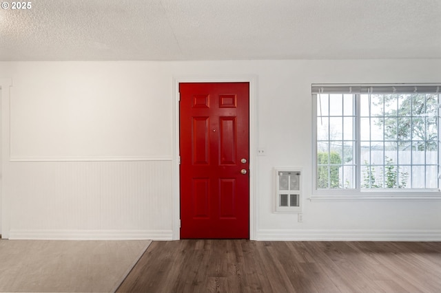 foyer with hardwood / wood-style floors, a textured ceiling, and heating unit