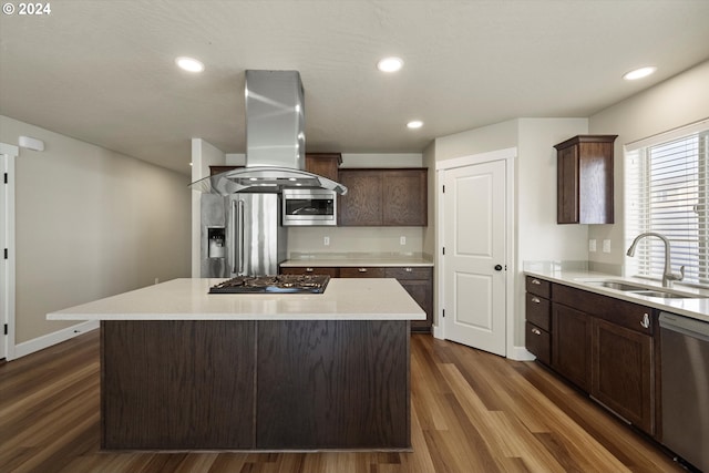 kitchen featuring dark hardwood / wood-style floors, sink, island range hood, a kitchen island, and appliances with stainless steel finishes