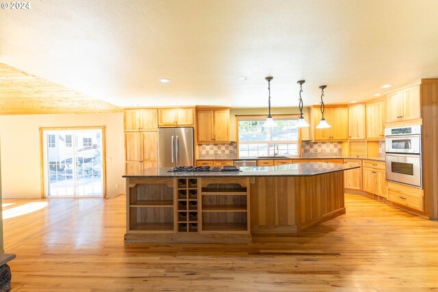 kitchen with a kitchen island, stainless steel appliances, and light hardwood / wood-style flooring