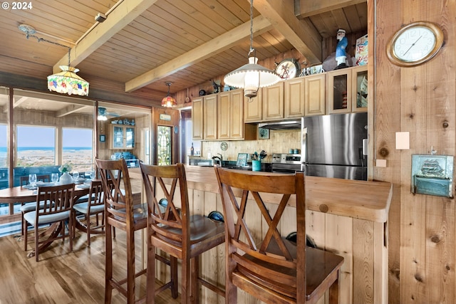 kitchen featuring appliances with stainless steel finishes, hanging light fixtures, wood ceiling, vaulted ceiling with beams, and light wood-type flooring