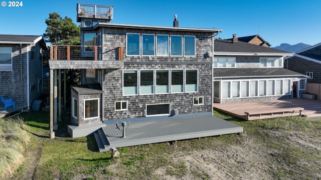 rear view of house with a balcony and a wooden deck