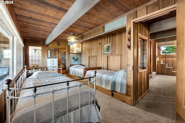 bedroom featuring wood walls, beamed ceiling, carpet, and wood ceiling