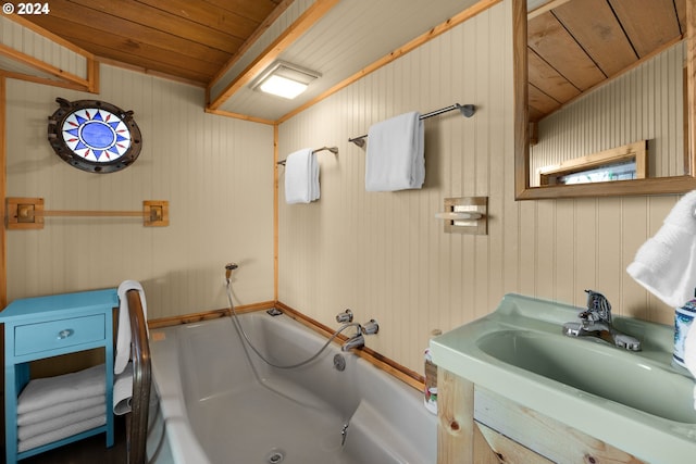 bathroom with a washtub, wood walls, sink, and wooden ceiling