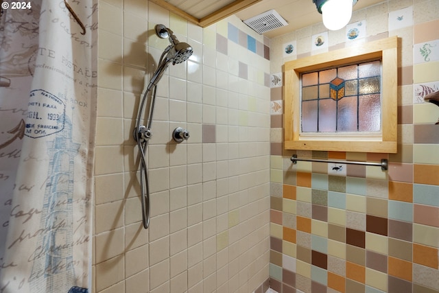 bathroom with a shower with curtain and tile walls