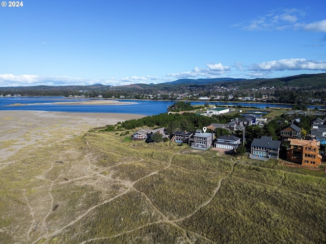 drone / aerial view featuring a water and mountain view