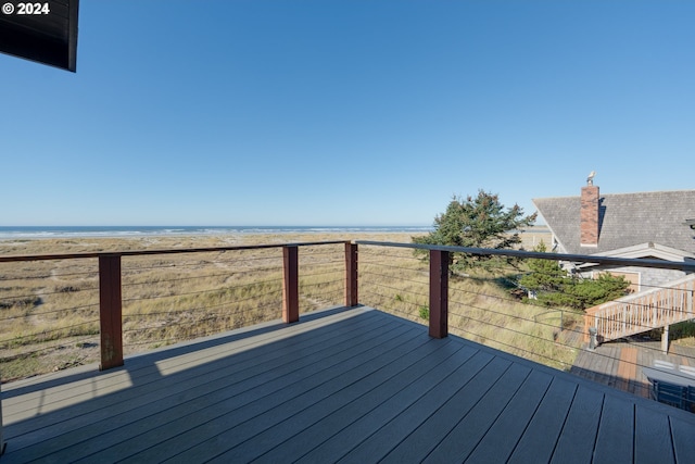 wooden deck with a beach view and a water view