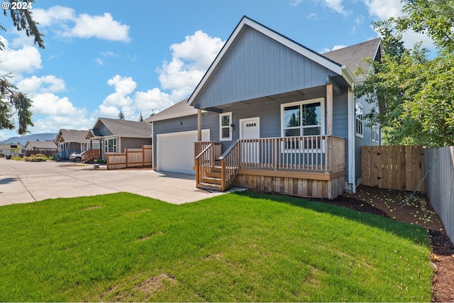 rear view of house featuring a garage, a porch, and a yard