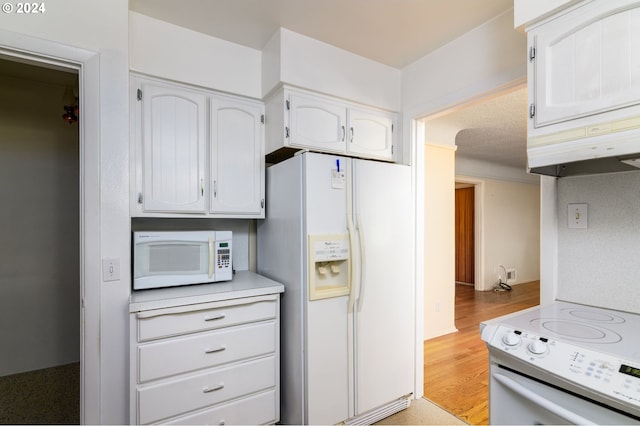 kitchen featuring white appliances, light hardwood / wood-style flooring, exhaust hood, and white cabinets