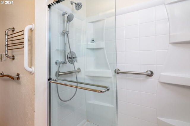 bathroom with a shower with door