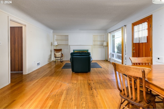 living area featuring a textured ceiling and hardwood / wood-style flooring