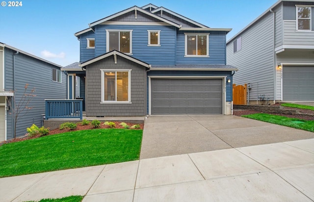 craftsman inspired home with a garage, concrete driveway, and a front yard