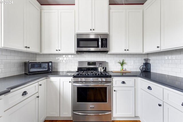 kitchen featuring white cabinetry, appliances with stainless steel finishes, and tasteful backsplash