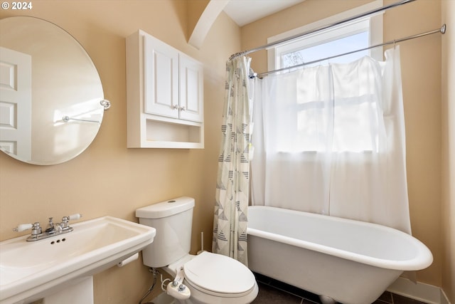 full bathroom with toilet, shower / bath combo with shower curtain, sink, and tile patterned floors