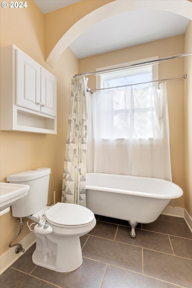 bathroom featuring tile patterned floors, toilet, and shower / tub combo