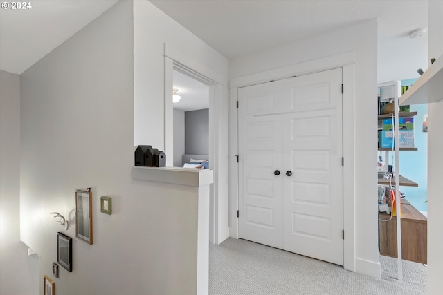 hallway featuring light colored carpet