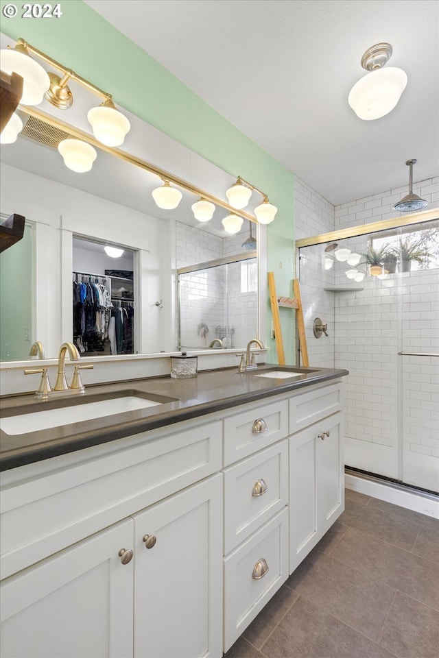 bathroom featuring vanity, tile patterned flooring, and a shower with shower door