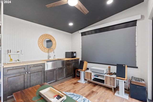 interior space featuring light wood-type flooring, sink, ceiling fan, and vaulted ceiling