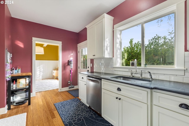 kitchen featuring white cabinetry, backsplash, sink, dishwasher, and light hardwood / wood-style flooring