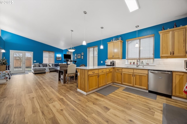 kitchen featuring kitchen peninsula, backsplash, vaulted ceiling, pendant lighting, and dishwasher