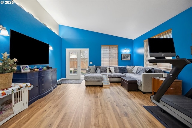 living room featuring light wood-type flooring and vaulted ceiling