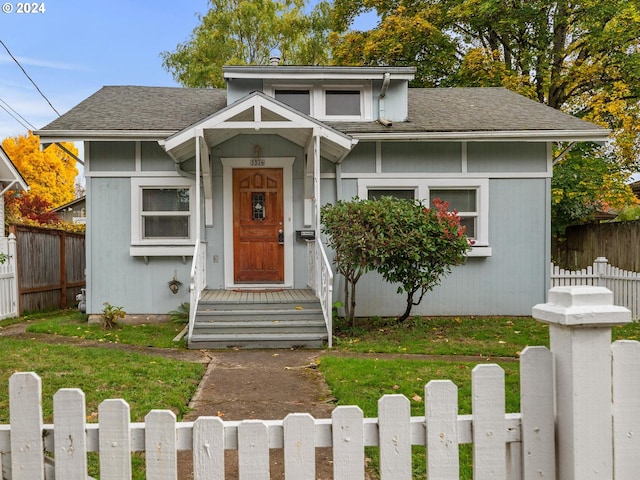 bungalow featuring a front lawn